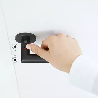 L'illustration montre la poignée de porte Lucia smart2lock de Griffwerk en Noir graphite avec une main d'enfant sur la poignée. La main ferme la poignée de porte au niveau du verrou.