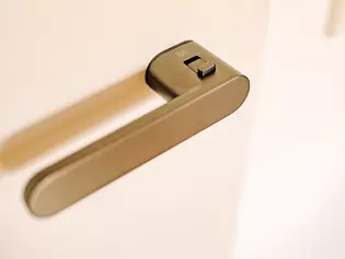 The illustration shows the AVUS ONE door handle in cashmere grey on a white door.