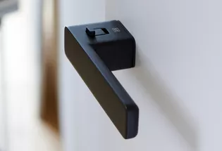 The picture shows the Griffwerk door handle R8 One smart2lock in graphite black from the side.