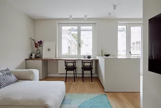 Die Abbildung zeigt einen Teil eines Wohnzimmers und Esszimmer mit Küche.