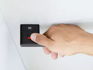  The picture shows the Griffwerk door handle R8 One smart2lock with a man's hand from above. The door handle is locked.