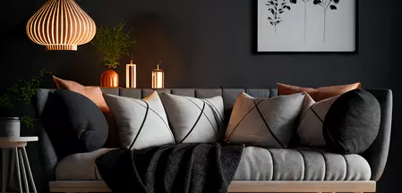 A stylish, minimalist living room with a cozy couch, decorative pillows and stylish lighting.