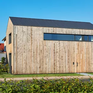 The picture shows the exterior of house vv with facades made of natural larch.
