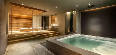 Die Abbildung zeigt ein Badezimmer mit Home Spa Bereich – luxuriöses Design mit entspannenden Elementen wie großer Badewanne, Sauna und sanfter Beleuchtung. Ein perfekter Rückzugsort für Wohlbefinden und Erholung zu Hause.