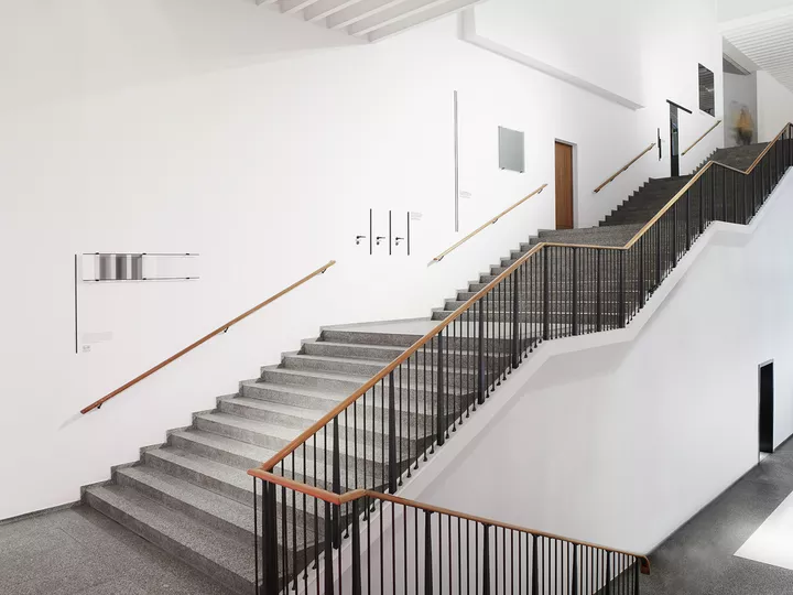 Die Installation befindet sich auf der gleichsam monumental wie grafisch klar anmutenden Treppe zum Obergeschoss des Museumsbaus