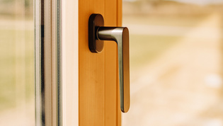 The illustration shows the Avus window handle in a house made of wood.