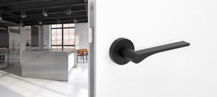 The picture shows the Griffwerk door handle LEAF LIGHT in graphite black in a living room.