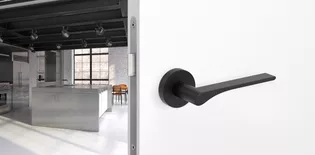 The picture shows the Griffwerk door handle LEAF LIGHT in graphite black in a living room.