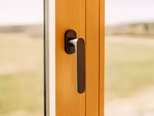 The illustration shows the AVUS window handle in a wood-style house.