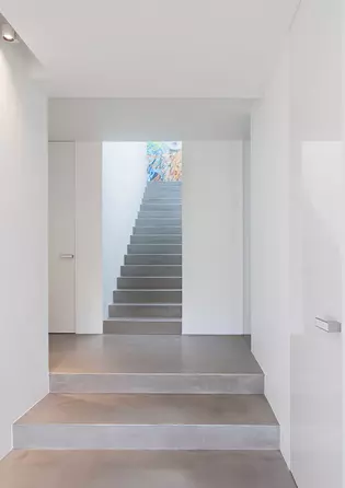 L'intérieur de la maison privée offre une générosité spectaculaire et met parfaitement en valeur les portes pivotantes à hauteur de plafond avec la ferrure de porte FRAME.