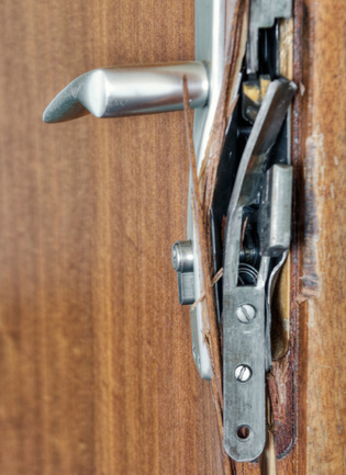 The illustration shows a bent up long plate fitting on a wooden door.
