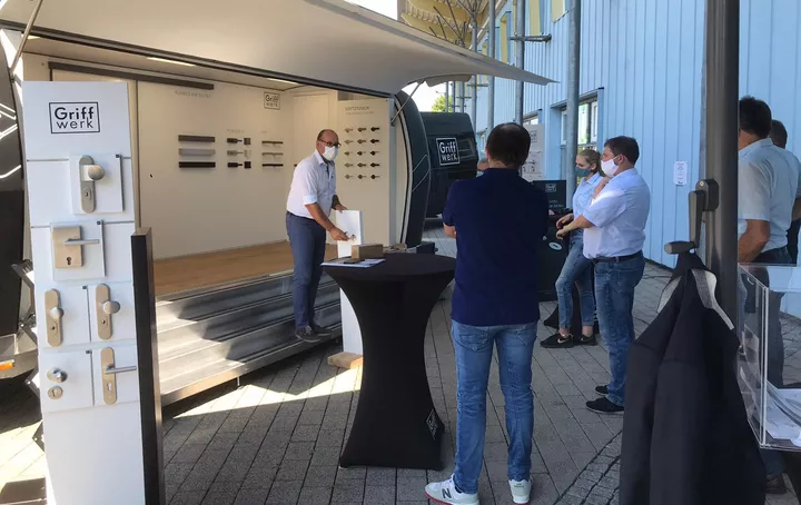 Das Foto zeigt den Griffwerk Roadshow Trailer zur Präsentation bei einem Griffwerk Fachhändler, mit vielen interessierten Zuschauern.