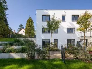 La ilustración muestra el edificio de apartamentos Lotthersgarten de Fürth desde el exterior, con un jardín delantero. 