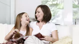 Die Abbildung zeigt eine Mutter mit ihrer Tochter in einem hellen Wohnzimmer.