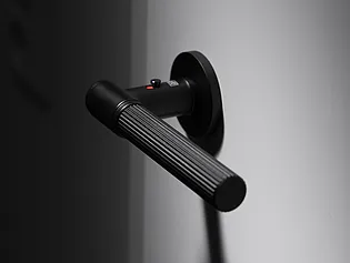 La photo montre la poignée de porte Griffwerk Vaya Aris smart2lock en noir graphite, vue de l'extérieur.