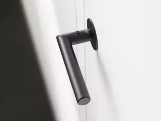 Poignées de porte Lucia Noir graphite L'illustration montre la poignée de porte Lucia noire montée sur une porte blanche. La poignée de porte est représentée en vue de dessus et la technique de fermeture smart2lock est réglée sur rouge.