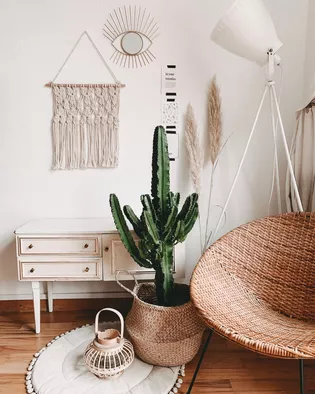 La imagen muestra un salón con mobiliario de estilo boho.