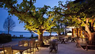 La foto muestra la terraza exterior del restaurante al atardecer.