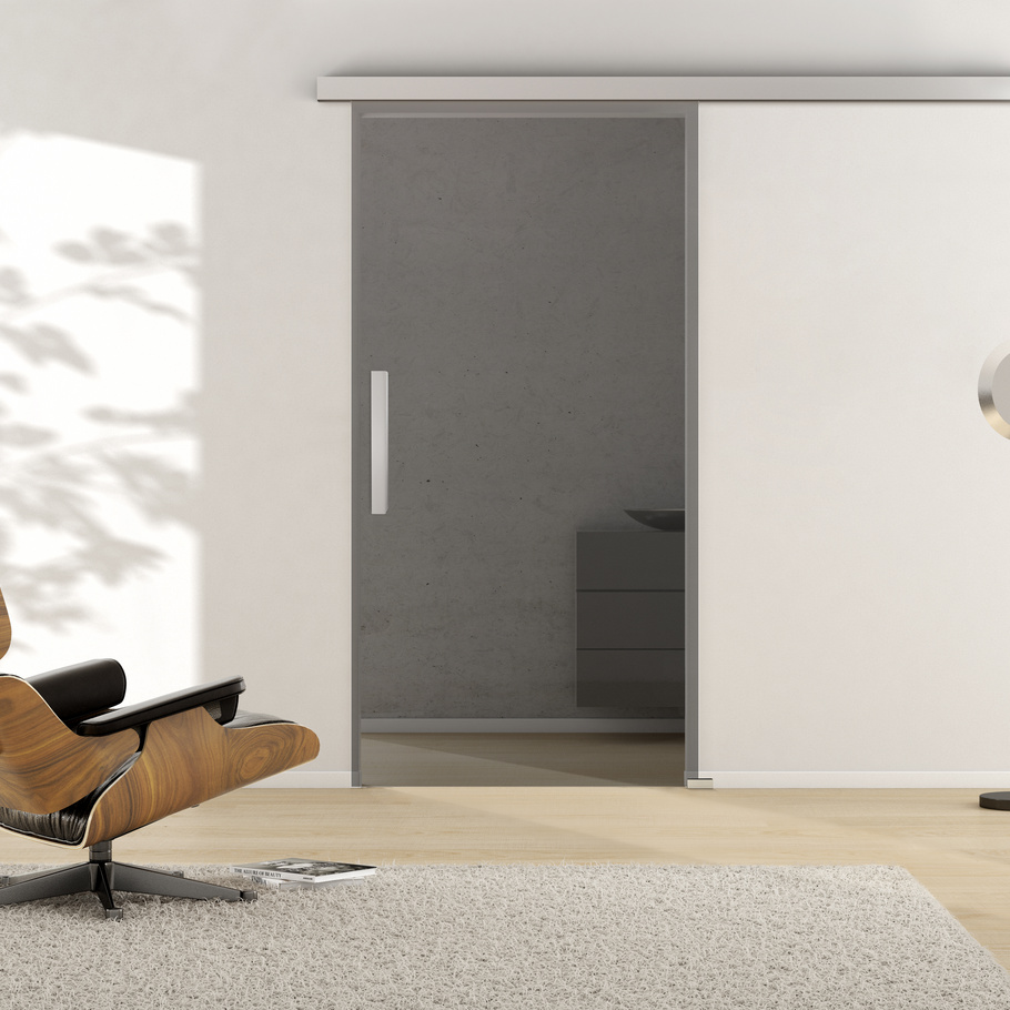 Ambientebild in Wohnraumsituation illustriert die Griffwerk Glasschiebetür SMOKED GREY 510 in der Ausführung ESG MOON GREY klar