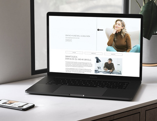 Ein Laptop und ein Smartphone liegen nebeneinander auf einem Schreibtisch. Auf diesen Medien ist die aktuelle Landingpage zur smart2lock Me-Time Kampagne abgebildet.