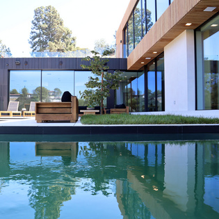 The picture shows the private house in Beverly Hills with pool and terrace in the front yard. 