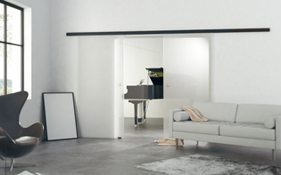 Die Abbildung zeigt einen Musikraum, der mit einer Glasschiebetürtür vom Wohnzimmer getrennt ist.