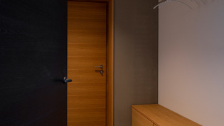 The picture shows the Ulm handle by Griffwerk in graphite black on doors in the dressing room of the Argenbühl manor house.