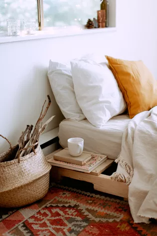 L'illustration montre un lit dans une chambre à coucher aménagée dans un style ethnique.