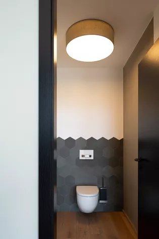 La ilustración muestra un cuarto de baño de la urbanización Argenbühl con la manilla Ulmer de Griffwerk en Negro grafito en la puerta.