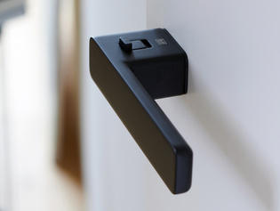 The picture shows the Griffwerk door handle R8 One smart2lock in graphite black from the side.