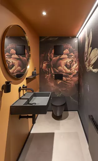 Die Abbildung zeigt die orange Toilette im Büro von Stanke Interiordesign in Euskirchen.
