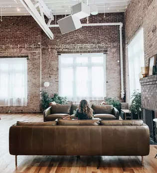 The illustration shows a living room with a sofa in an industrial style.