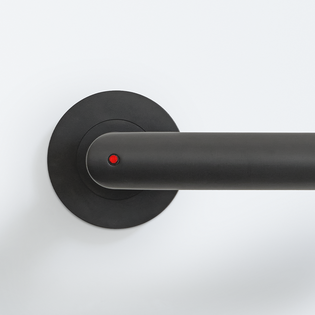 The picture shows the Griffwerk door handle Lucia smart2lock in graphite black from the outside. A red dot on the door handle shows that the door is locked.