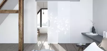 Wohnsituation zeigt die GRIFFWERK Glastür BIRDS & BIRD_LD_695 in der Ausführung Schiebetür ohne Bohrung - Einscheibensicherheitsglas PURE WHITE Laser / Siebdruck