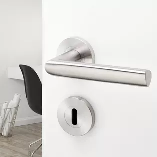 The illustration shows door handle TRI 134 in matt stainless steel on a white door with a study in the background.