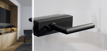 The picture shows the Griffwerk door handle Puristo S with smart2lock in graphite black in a living room.