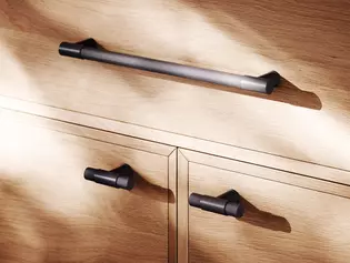 Die Abbildung zeigt einen langen Möbelgriff und zwei kurze Möbelgriffe der Reihe Aris.