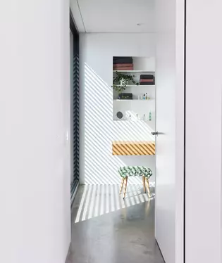 Das Bild zeigt den Blick vom Flur in das Bad im Haus ana. Die Tür mit Türgriff Lucia Professional smart2lock ist geöffnet.