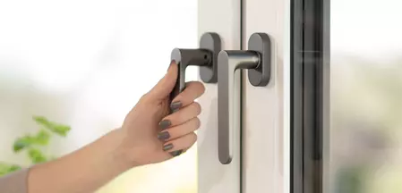 Manilla de ventana Avus de Griffwerk en gris cachemira con mano en la manilla