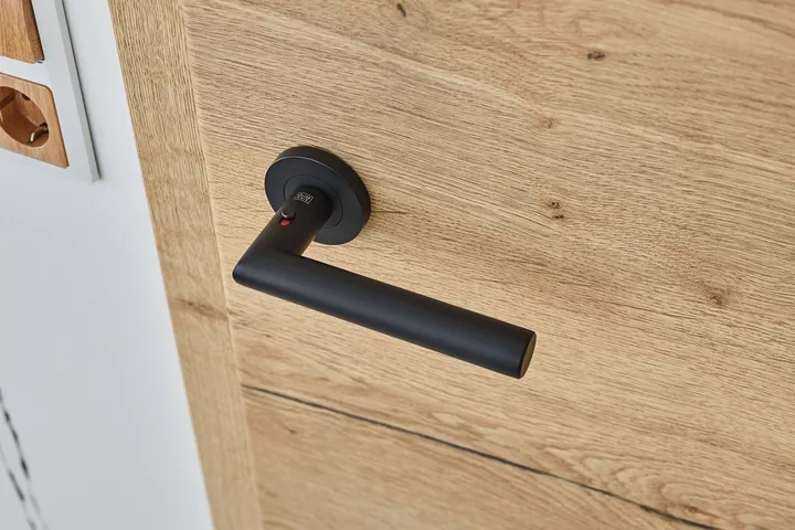 The picture shows a Griffwerk Lucia smart2lock door handle in graphite black.