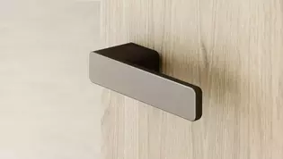 In the picture you can see the door handle R8 ONE in cashmere gray on a wooden door.