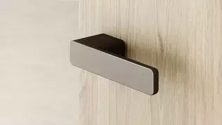 Imagen de R8 ONE en Gris cachemira La imagen muestra las Manillas de puerta del R8 ONE en Gris cachemira sobre una Puerta de madera.
