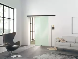 L'illustration montre un salon moderne avec la porte coulissante en verre Planeo AIR de Griffwerk sur un mur.