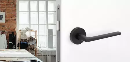 The picture shows the Griffwerk door handle Remote in graphite black in a living room.