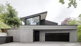 Maison d'habitation moderne à flanc de coteau avec vue sur la vallée de la Murg Maison d'habitation unique sur le plan architectural, construite à flanc de coteau avec du béton apparent, de grandes baies vitrées et un toit en saillie. Alliance harmonieuse de la nature et de l'architecture moderne.