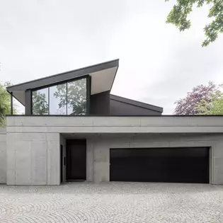 Maison d'habitation unique sur le plan architectural, construite à flanc de coteau avec du béton apparent, de grandes baies vitrées et un toit en saillie. Alliance harmonieuse de la nature et de l'architecture moderne.