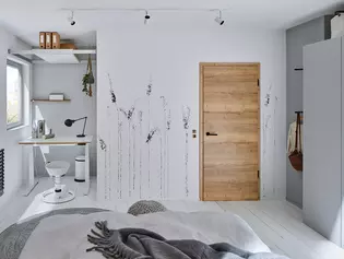 La photo montre une chambre d'adolescent avec une porte en bois et des poignées de porte Lucia noires avec la technique de fermeture smart2lock.