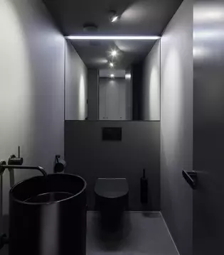 Die Abbildung zeigt die Gästetoilette in schwarzem Stil mit schwarzer Tür und graphitschwarzem Türgriff Avus One im Konzeptapartment VOID
