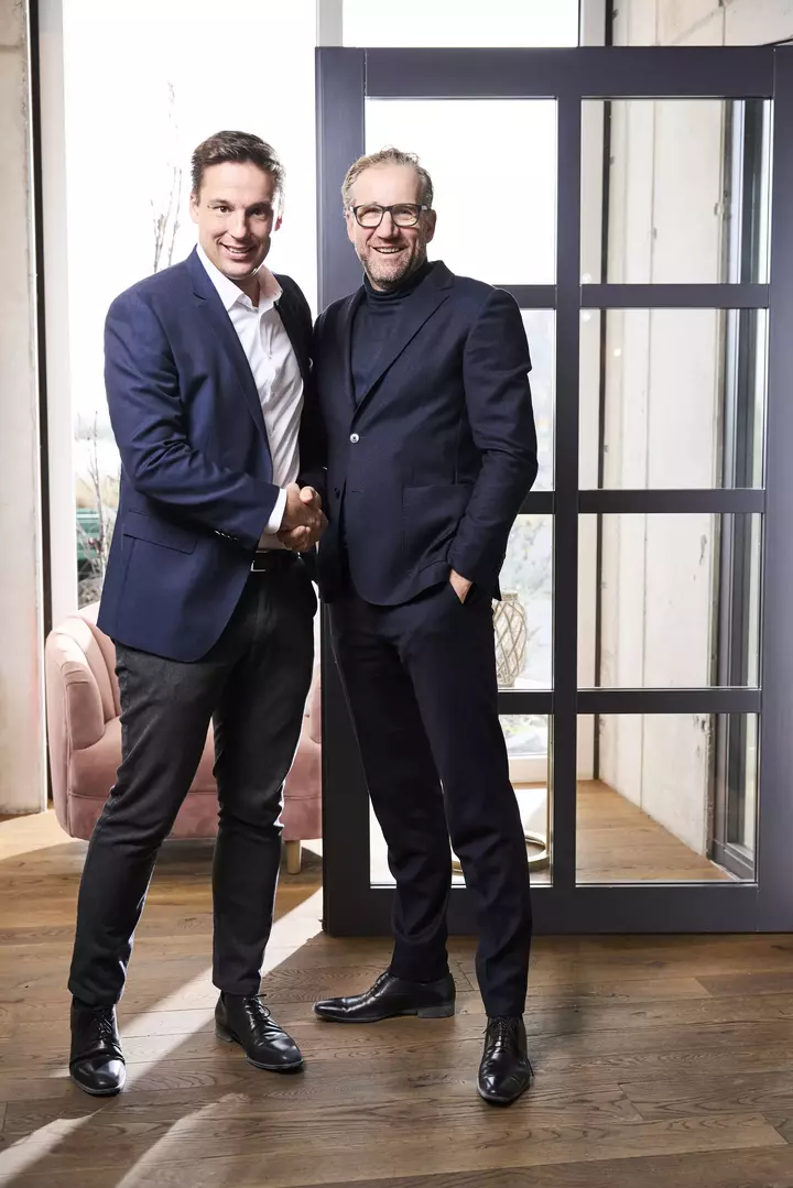 Auf dem Bild sind Claudius Moor (CEO der Division Türen und Mitglied der Konzernleitung der Arbonia AG) und Matthias Lamparter (Geschäftsführer der Griffwerk GmbH) zu sehen. Beide geben sich die Hand.