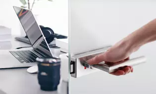 Image Puristo S by Griffwerk and bureau The illustration shows the Puristo S door handle by Griffwerk on a light-colored door with a desk in the background.